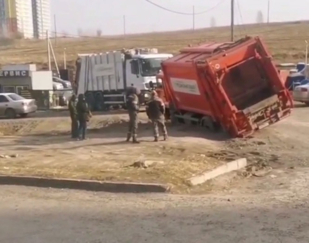 В Красноярске мусоровоз провалился в яму при выезде со двора